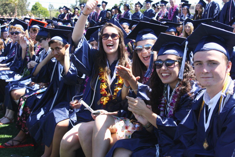 Seniors cheer down their classmates as they walk down the aisle. cheer-down-aisle