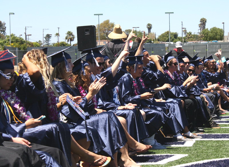 Seniors cheer down their classmates as they walk down the aisle. cheer