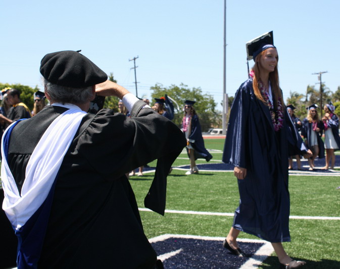 Physics teacher George Stimson takes photos of alumni Chelsea Kanzler as she walks down the aisle. chelsea