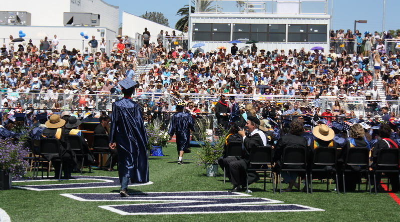 Students walk down the aisle to receive their diploma from principal Timothy Hornig. down-the-aisle