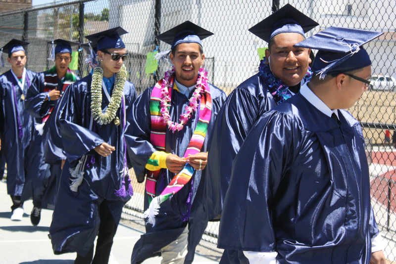 Students leave the tennis courts to begin walking to their seats. guys-walking