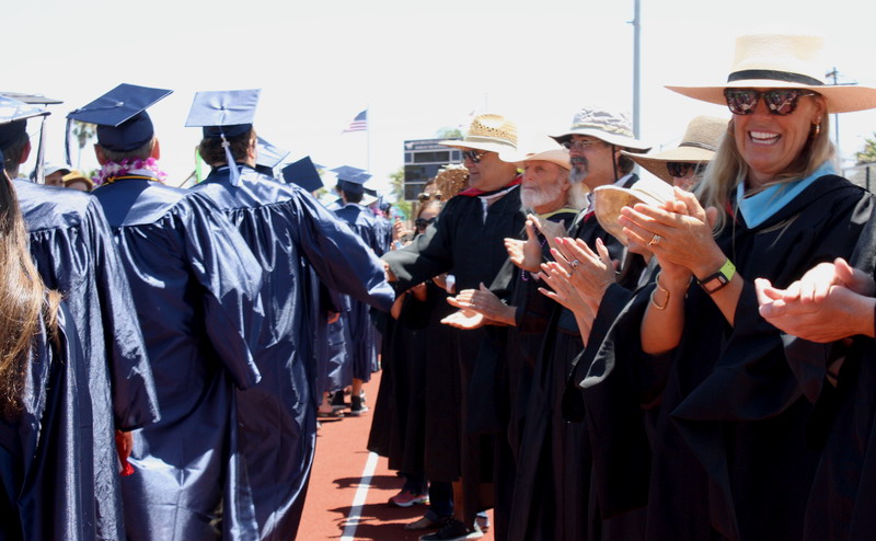 Teachers applaud the seniors for four years of hard work. more-teachers