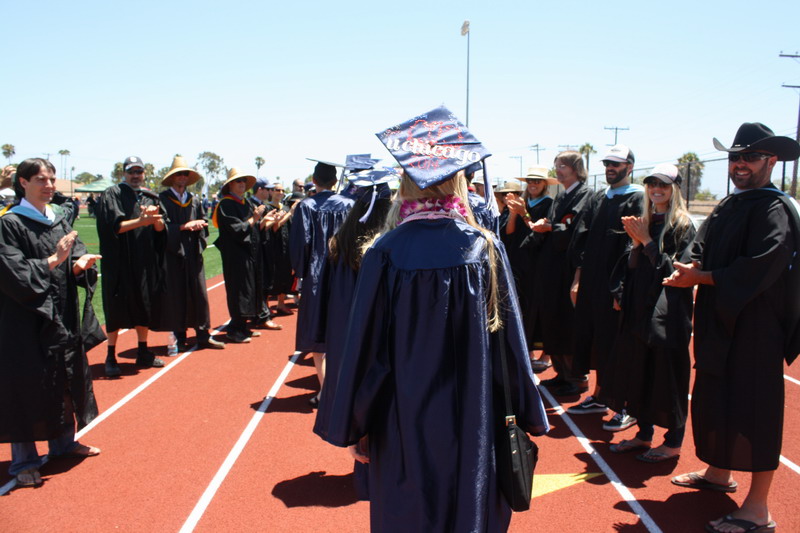 Teachers make a tunnel for seniors to walk through. walking-through-teachers