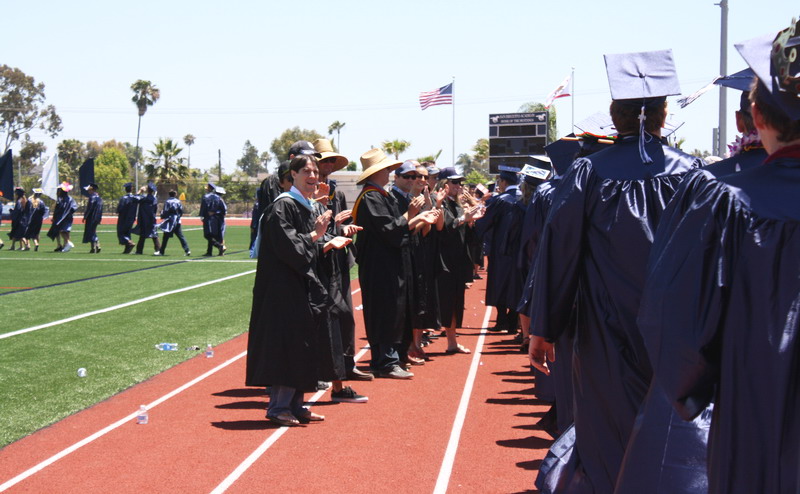 Teachers applaud students as they walk to their seats. walking-to-teachers