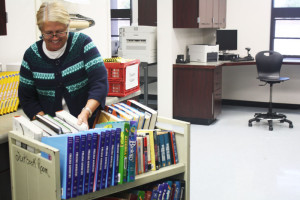 Librarian Donna Gonzales sorts through recently returned books. However, many textbooks are still missing from fall semester.