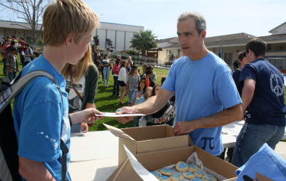 A student recieves the prize package from math teacher Paul Brice after reciting the required number of pi digits.