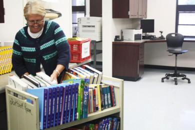  Librarian Donna Gonzales sorts through recently returned books. However, many textbooks are still missing from fall semester.