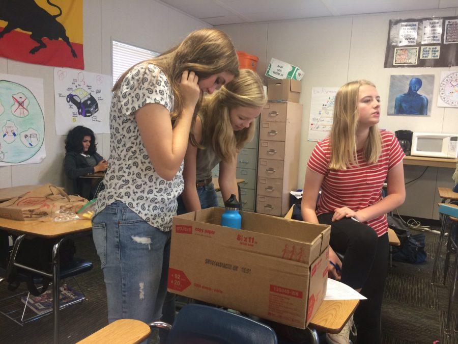 Sophomores+Lucy+Ryall%2C+Linnea+Erisman+and+Sylvia+Young+of+Spanish+teacher+David+Bairs+homeroom+add+newly+found+objects+to+their+scavenger+hunt+box.