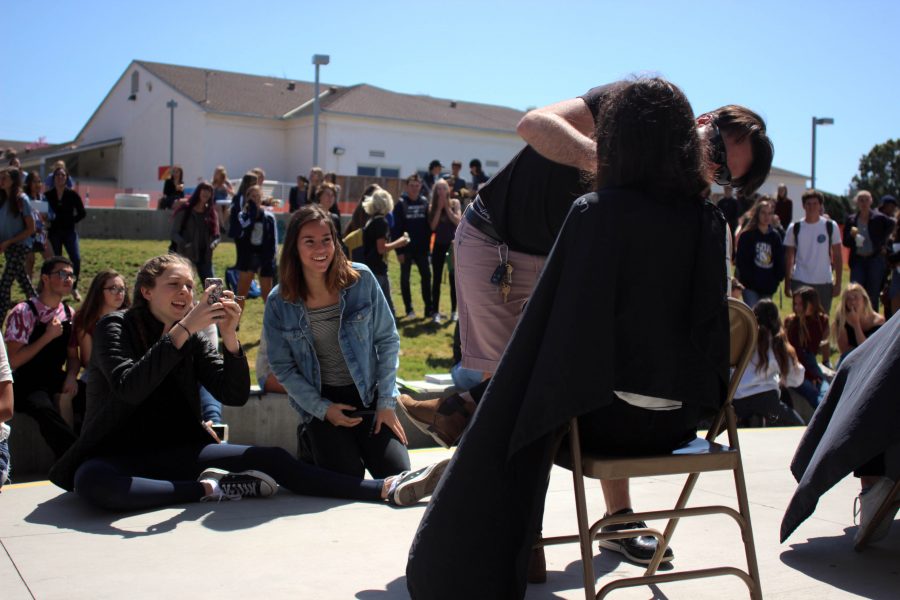 Students excitedly watch as others get their hair cut in front of the PAC.