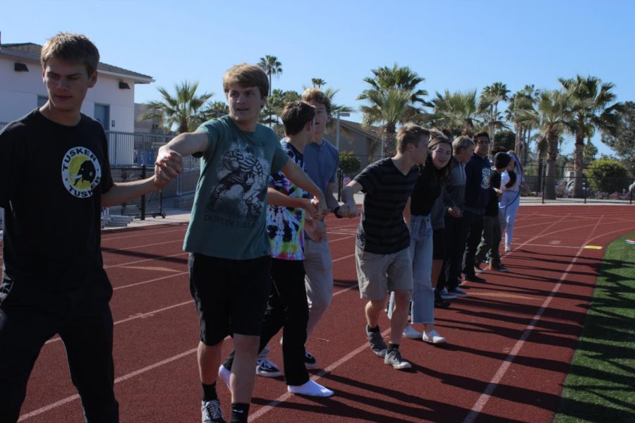 Students link arms as part of the relay race event.