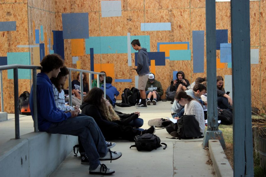 Students sit outside their homeroom class while waiting for doors to be unlocked.