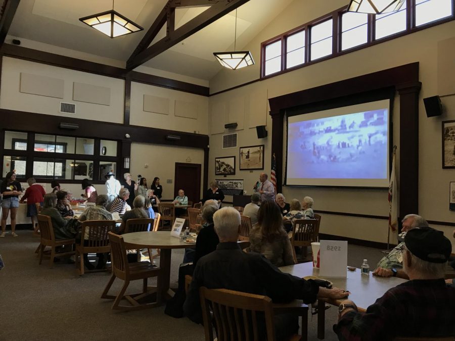 Principal Adam Camacho greets the SDA Alumni as an old video reel plays.