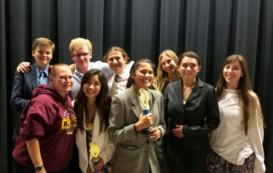 Speech+and+Debate+team+members+and+teacher+Lily+Bolig+stand+proudly+with+their+trophies+after+last+weekends+tournament.