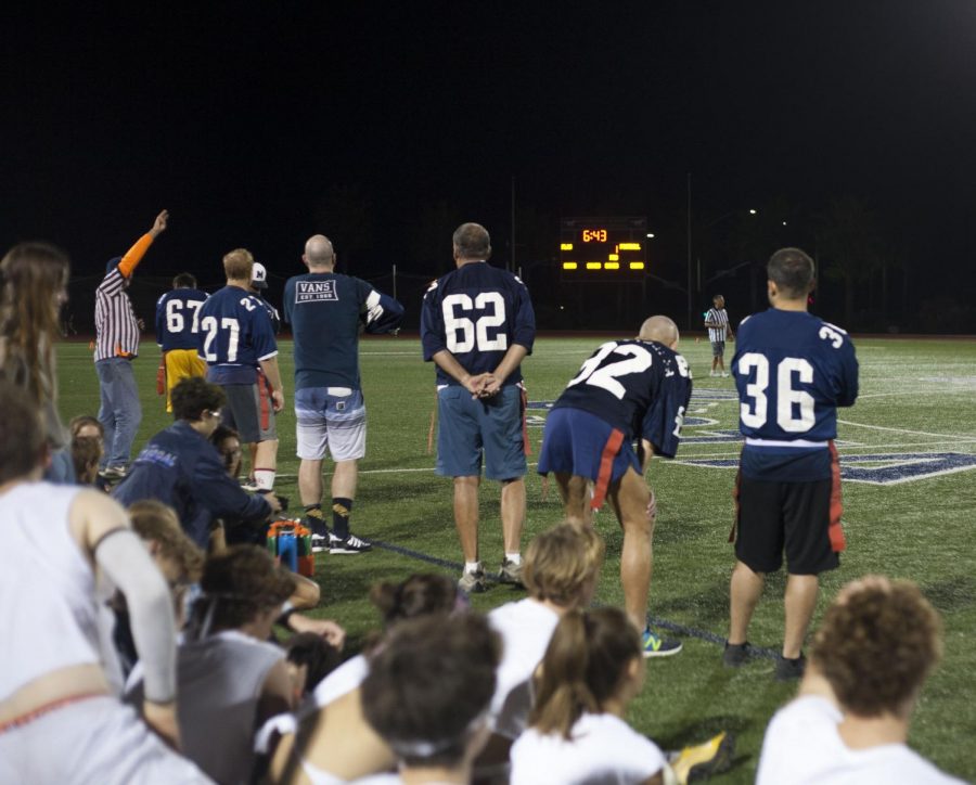 Teachers wait on the sidelines during the second quarter of the game.