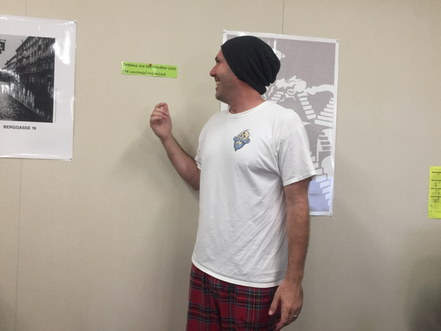 AP Psychology teacher, James Hrzina, shows off his pajamas in front of a quote about dreams by Sigmund Freud.