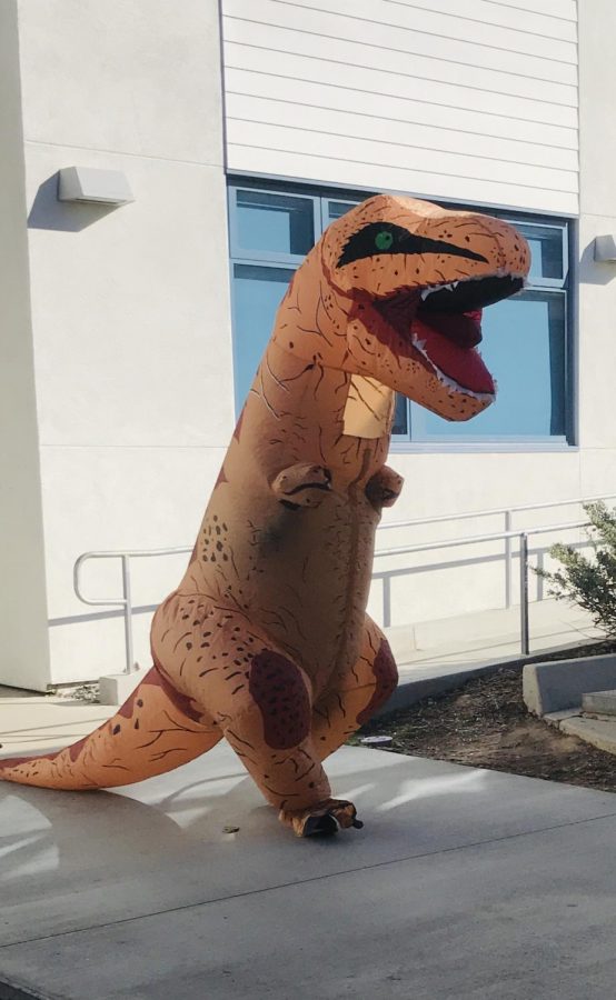 An anonymous student wanders the halls dressed as a dinosaur.