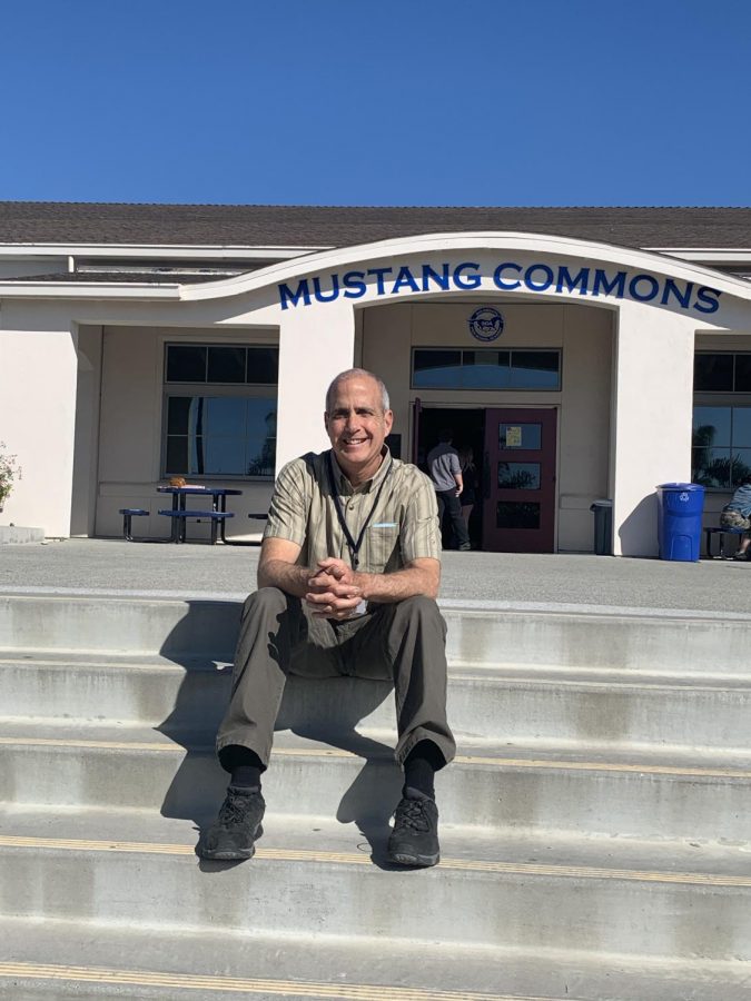 Math teacher Paul Brice sits in front of the Mustang Commons.