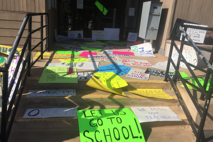 People leave signs in front of the district office with messages like 'Let us go to school!' 