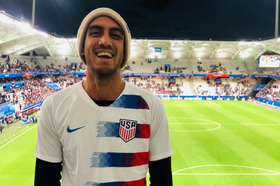 Mr. Ramirez poses in front of a soccer stadium rooting for USA