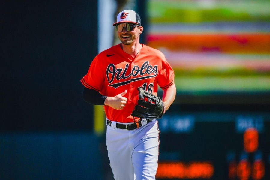 Trey Mancini in an orange shirt with a cap and baseball gloves