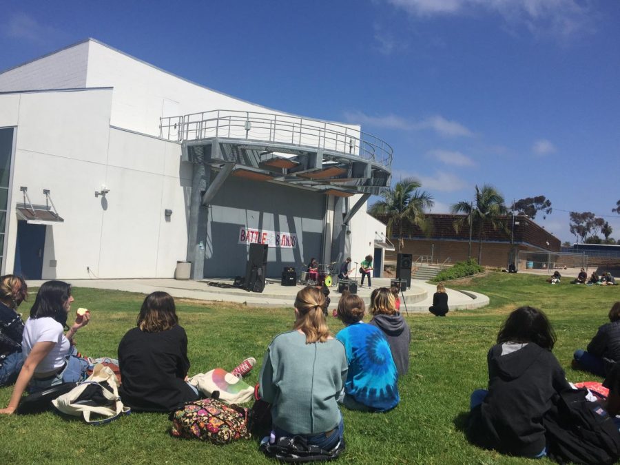 students sitting on the grass while watching in the pac