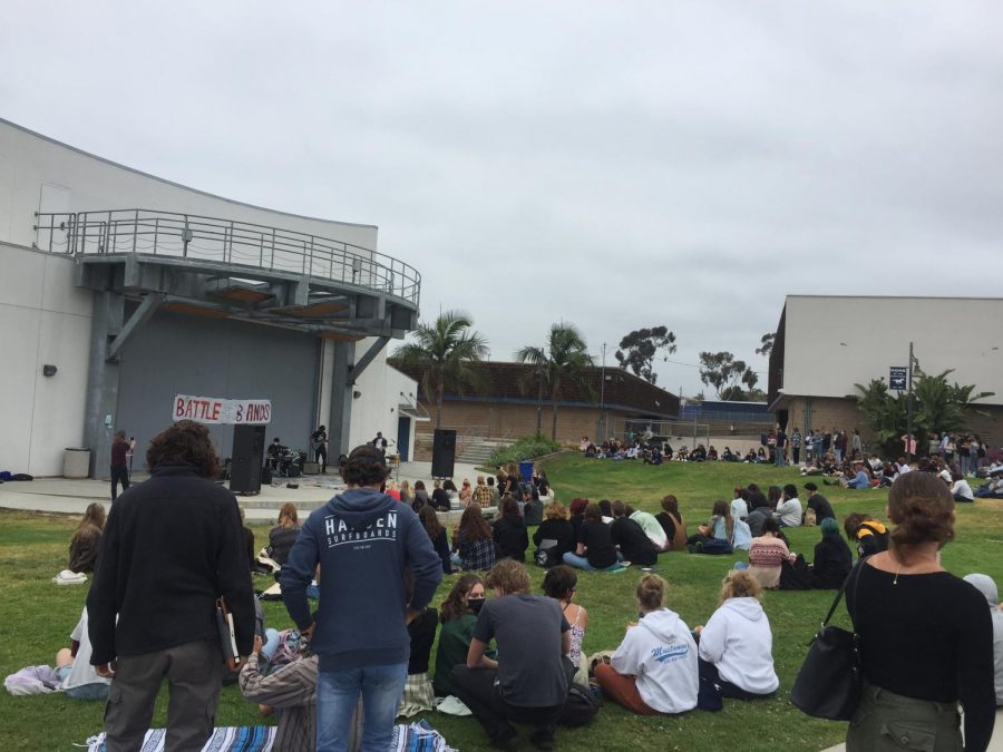 Students sat on the grass while watching bands perform during lunch on May 11, 2021