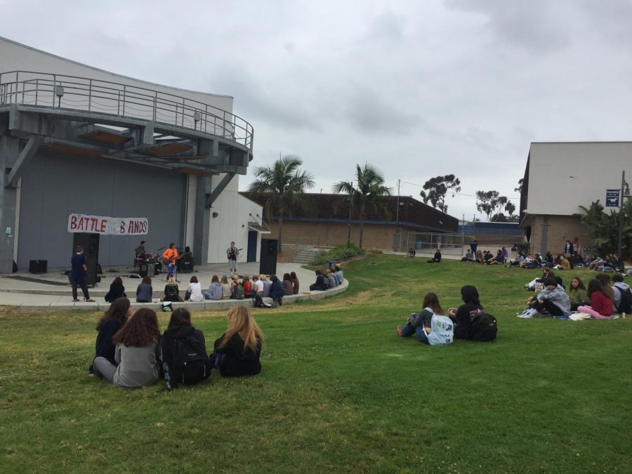 students+sitting+on+the+grass+while+watching+in+the+pac