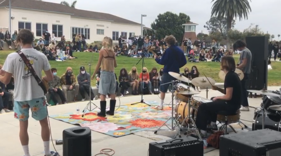 four band performers with crowd in front